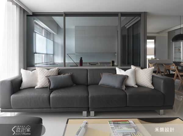入門大片的落地窗，拉簾引進明亮的採光，為低彩度的灰