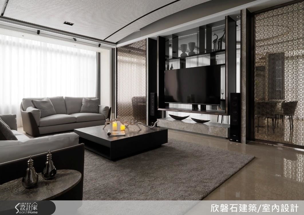 客廳天花茶色立面鈦金框塑以小 6 角磚鋪陳為面的前衛圓拱造型修飾樑體，展現工藝崛起精湛細緻，佐以黑色鐵件與燈帶引導視覺延伸空間尺度。落地窗前分別以深淺色大理石材鋪敘佐異材質搭配，藉以色彩與燈光渲染豐富空間的視覺層次。