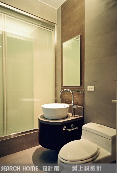 同樣是一字型衛浴空間，利用石材從台面延伸到浴缸，線