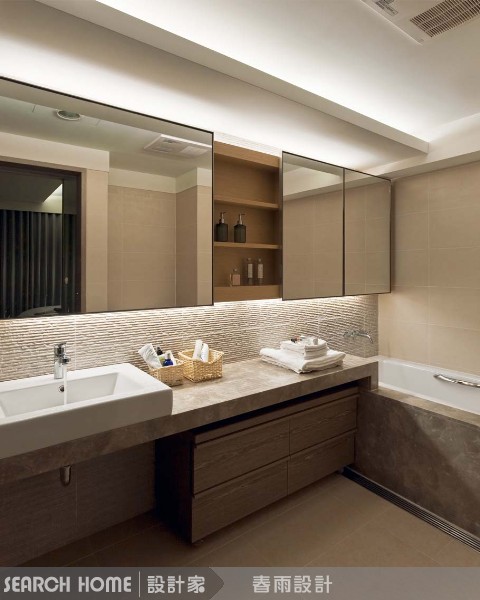 同樣是一字型衛浴空間，利用石材從台面延伸到浴缸，線