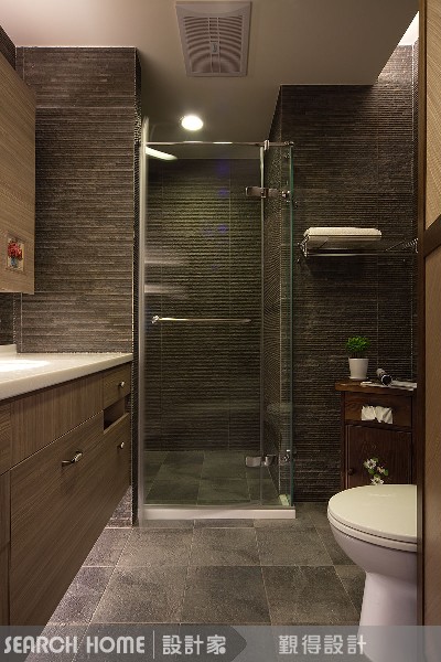 同樣是一字型衛浴空間，利用石材從台面延伸到浴缸，線