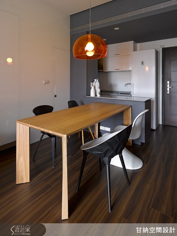 透过中岛吧檯与灰阶色彩，区隔出客厅与餐厨空间的区域感，灰阶的色彩，更创造出一股迷人的沉稳气息。