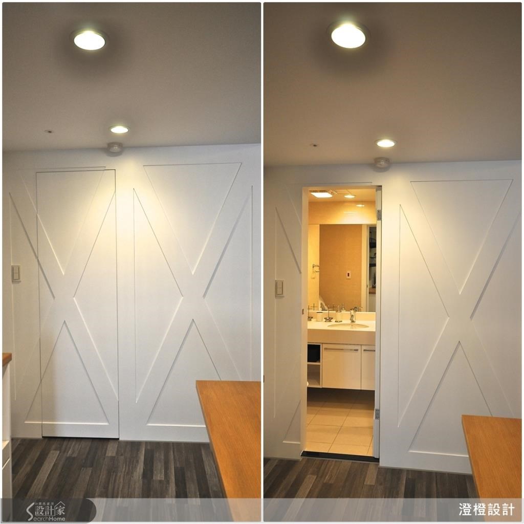 猜猜看～这两扇有如仓库大门的白色木门背后隐藏了什么空间呢？答案是卫浴！藉由造型设计，让整面墙与拉门形成一致的视觉效果，把卫浴空间巧妙藏起来，让空间感更完整，同时也是十分独特的创意表现呢！