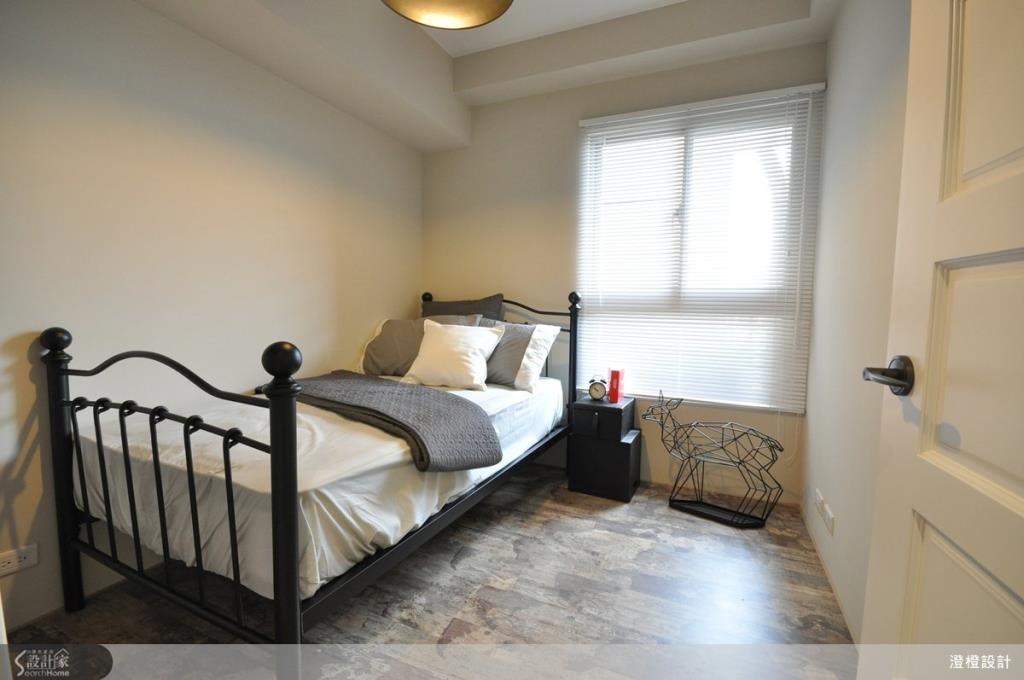 次卧以带有刷旧纹理的木质地板铺陈空间，搭配黑色铁件床架，带来一种怀旧又浪漫的复古调性