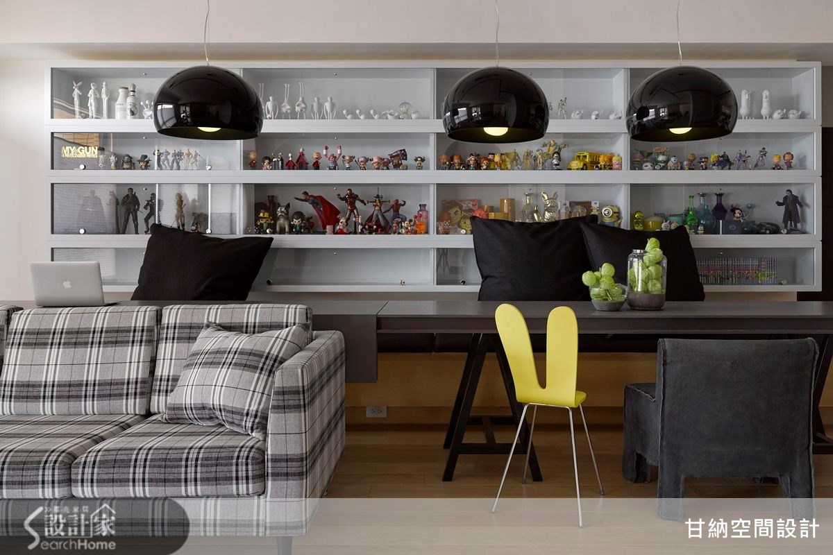 採用黑色系來整合空間，不規則吊掛3盞吊燈、大尺度抱枕、bench上黑色坐墊、不規則啡色地毯、以及像主角般的黑色格子沙發。