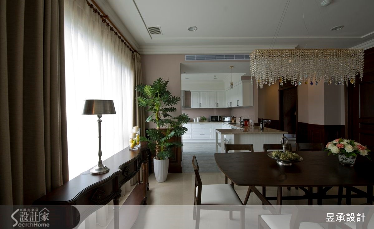 餐廳、廚房在敞闊大氣的空間氛圍下，以白色廚具加上相近於牆色的特調藕紫色烤漆玻璃，利用光線與色彩的拼貼，架構出內外一致的空間配色及流動的視覺動線。