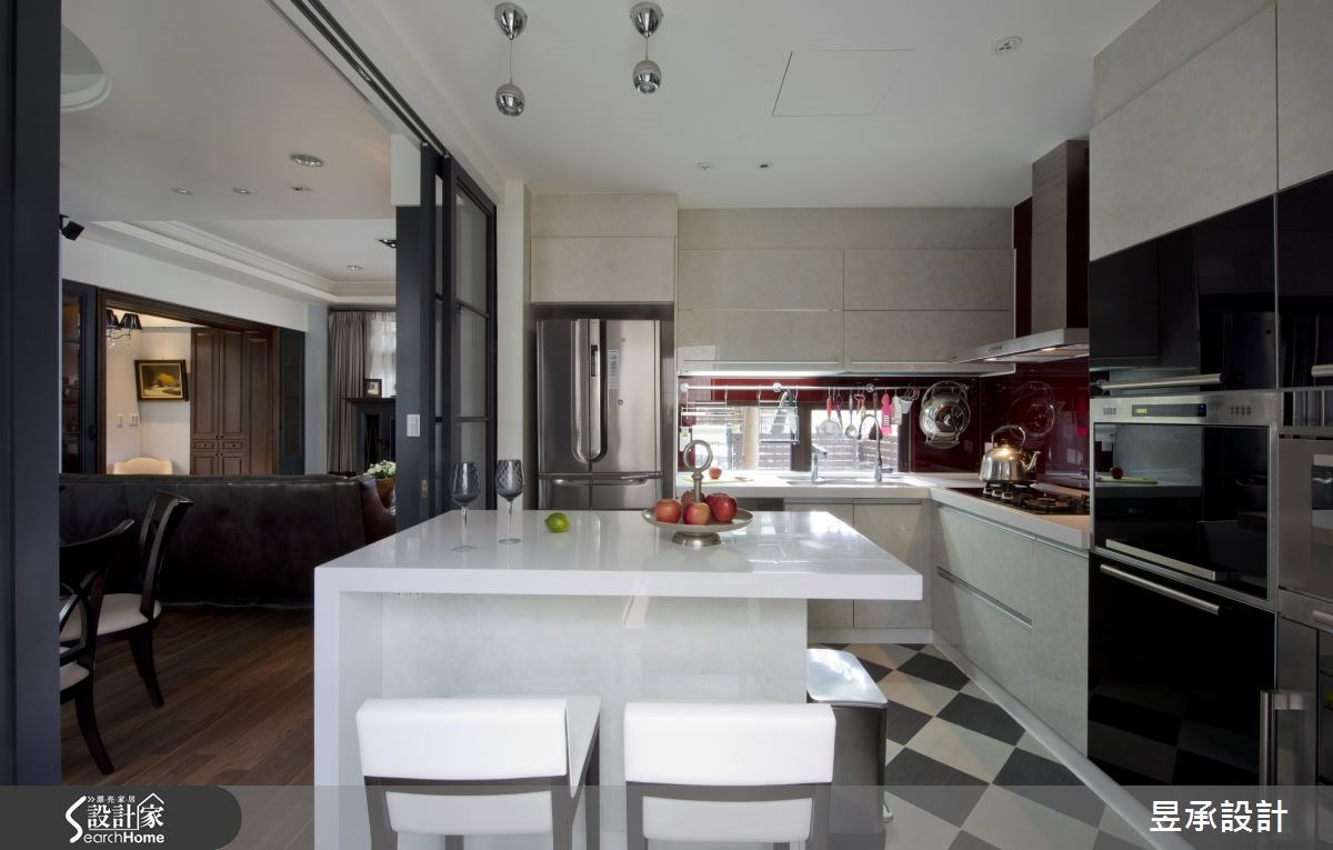 經過移位與檯面重新建置的廚房中島吧台，純白色的吧台主體與斜貼的黑白地磚相呼，很有美式廚房的味道。