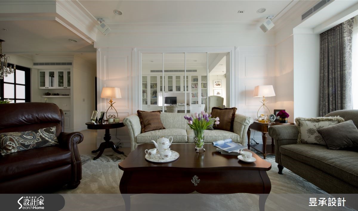 客廳的沙發背牆，兩側採對稱的立體壁板設計，中間則利用玻璃隔間牆，增加空間串連性與穿透性，同時也加大了空間的視覺深景。