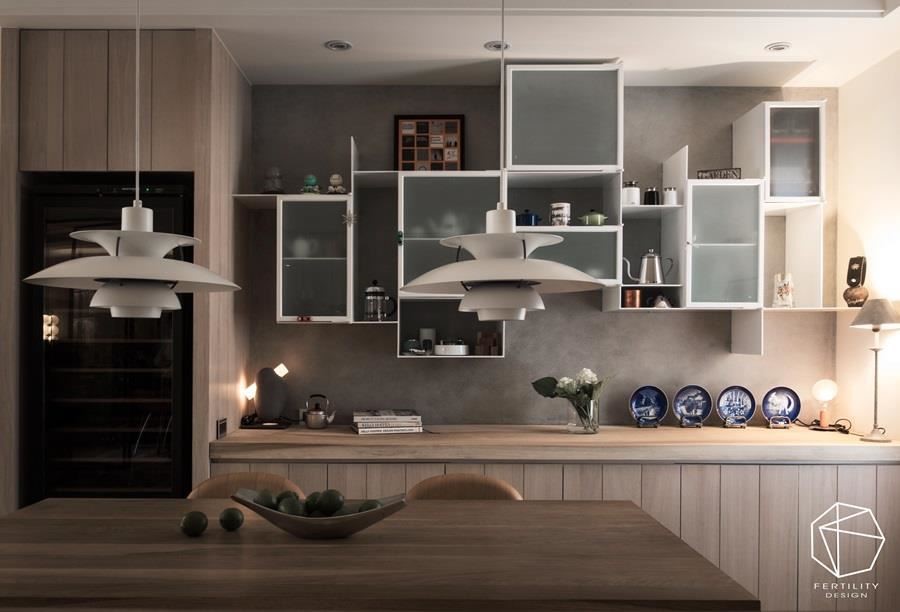 厨房墙面装设白色悬吊柜，以铁件、玻璃作出柜面层次，展示全家人的旅游纪念品。