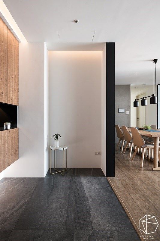 入口玄关区域，以木地板与深色砖材铺陈地面，做出内外场域的划分。