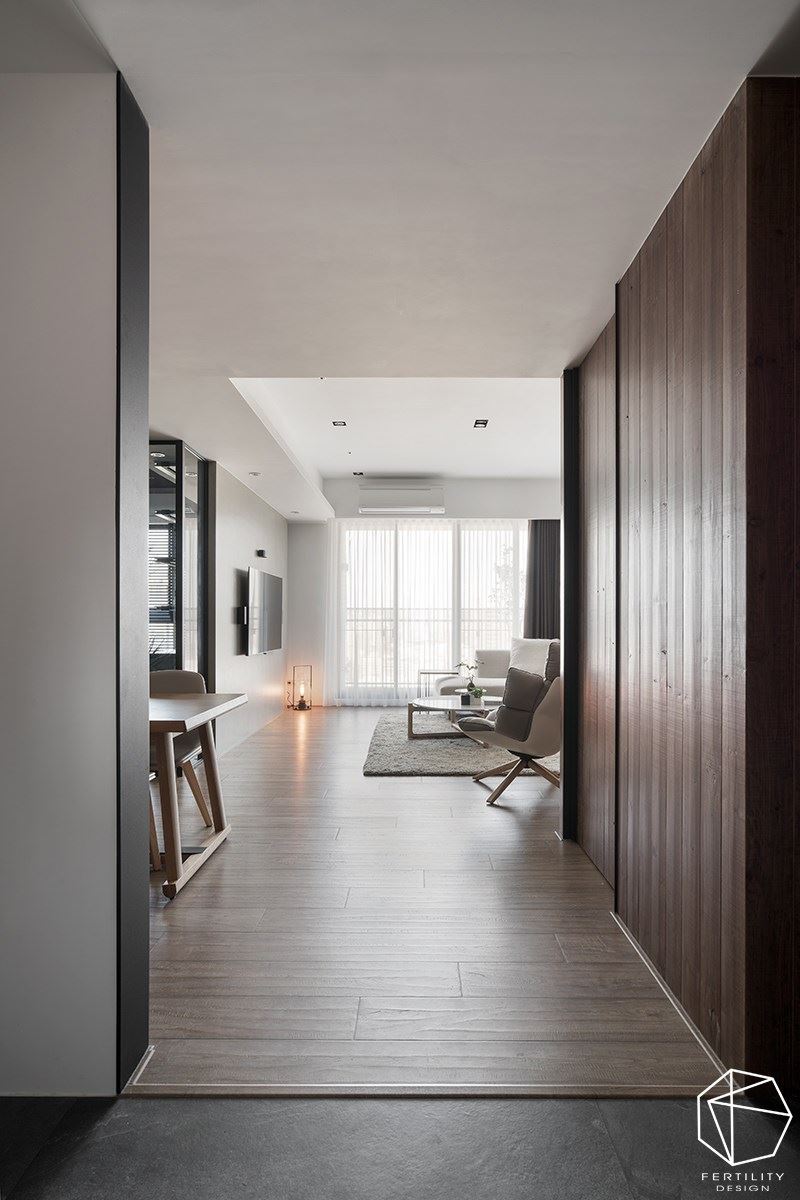 设计师透过格局的调动，在玄关区增设储藏室，提供杂物与大型对象摆放，减少柜体的零碎存在。