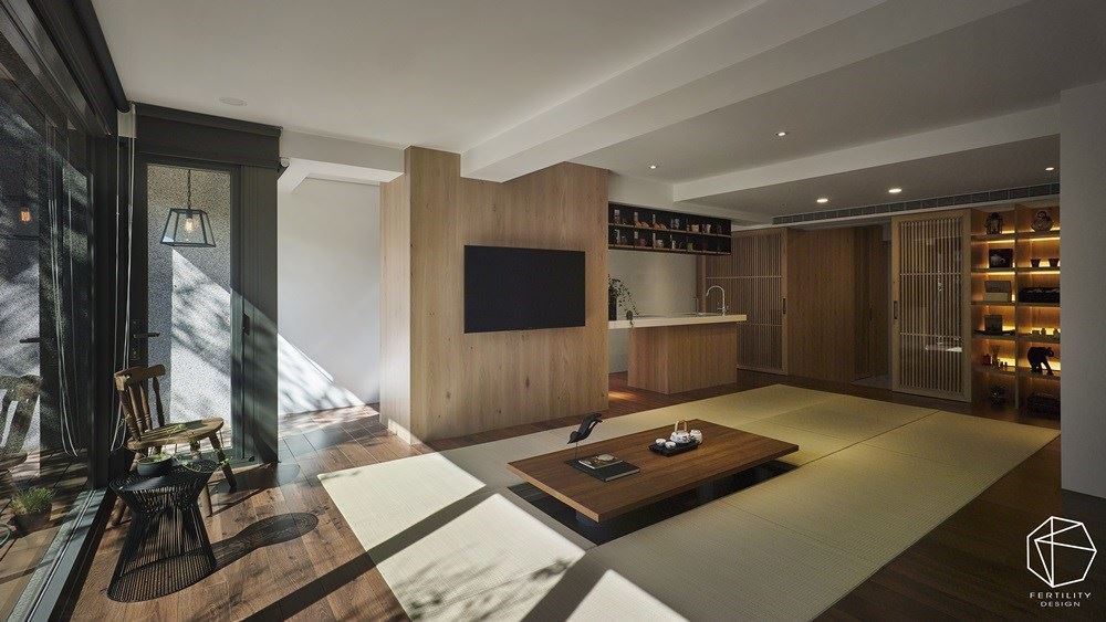 规划木皮电视墙，区隔吧台及中央的交谊区，串起和室各个使用区块，预留出宽敞的流畅动线。木皮电视墙后方则作为电器柜使用，结合一旁的中岛，同时安装电动升降桌，创造机能性十足的聚会空间。