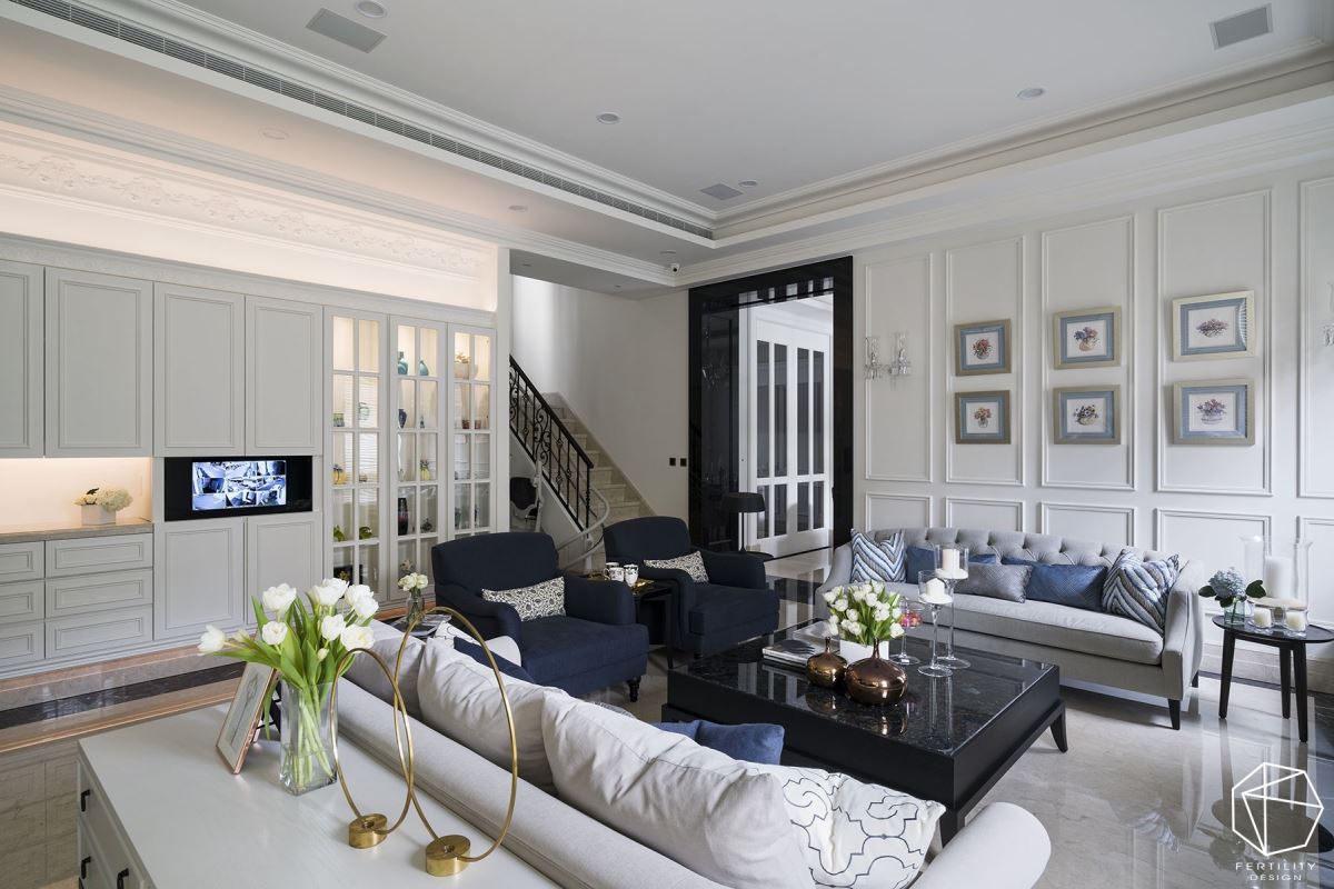 白色基底，搭配蓝色沙发与家饰品，于墙面装饰相框，体现丰富的视觉层次。