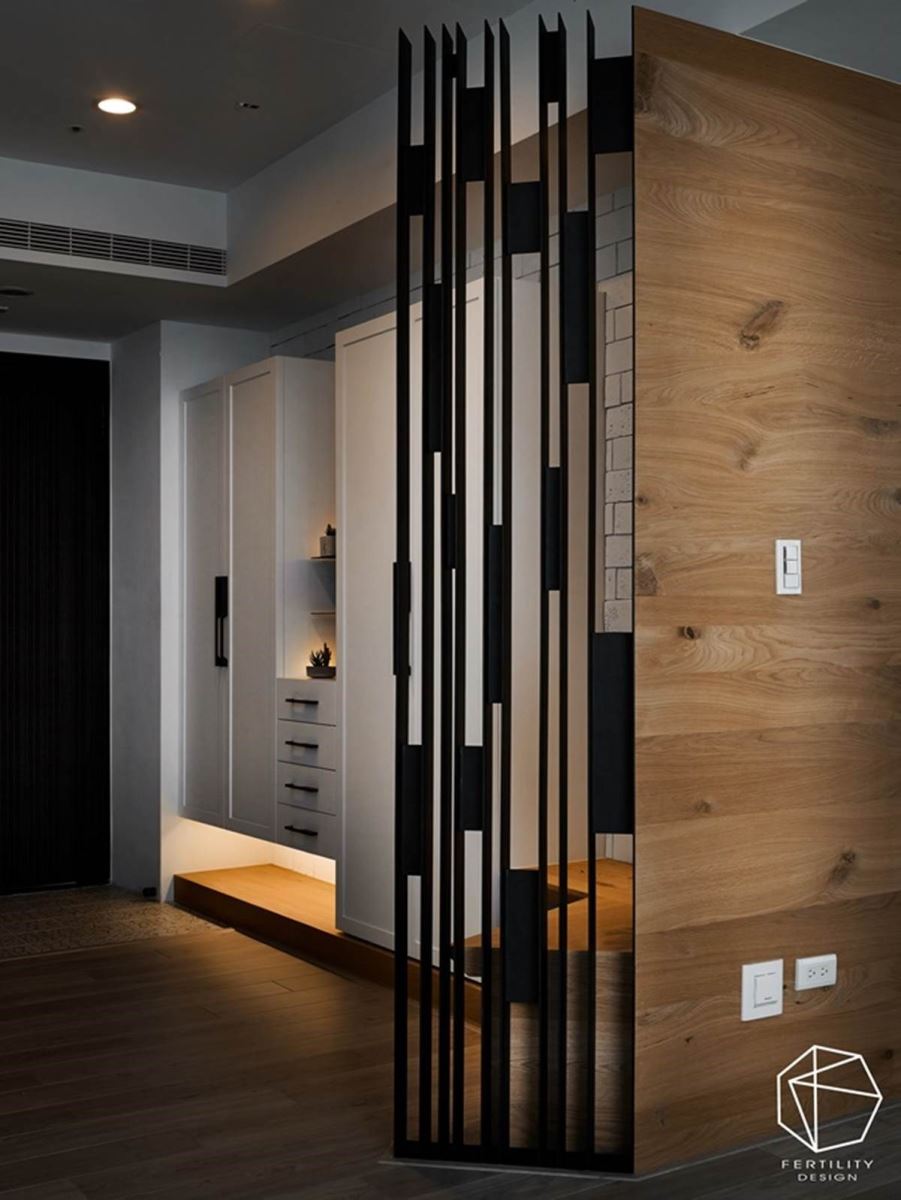 为了风水考虑，避免进门即见窗，在玄关与客厅间装设铁制格栅的木板，不仅解决风水问题，也替空间带来独特的层次感。