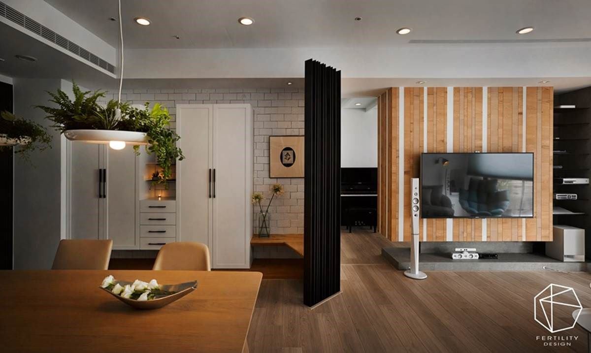 特色的木质电视墙面与整屋的木地板相辅相成，从入口处沿墙安排储物展示柜体，并结合穿鞋凳，在末端安排铁件隔屏，以非直角的造型活化空间线条。