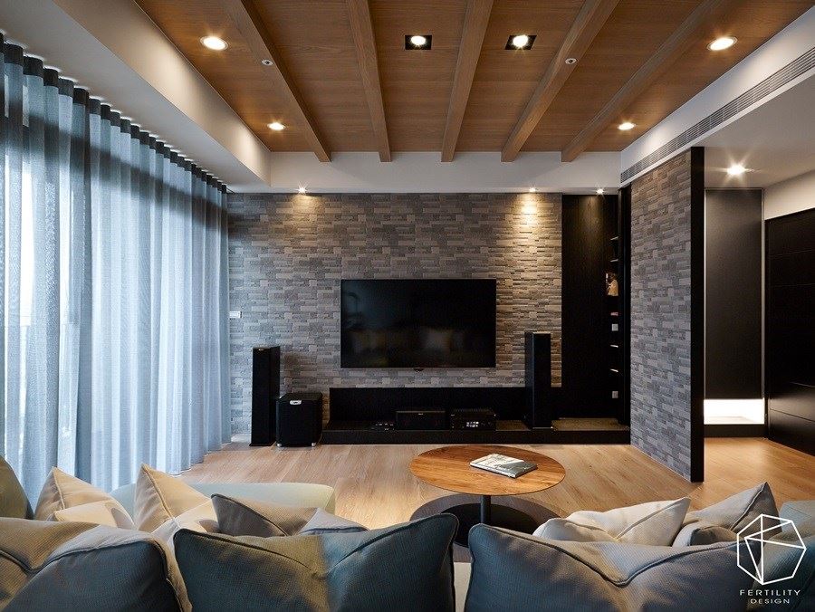 电视墙则延续石件材质，创造大面积的视觉律动性，并选用深色柜体镶嵌于墙面，增添收纳机能。