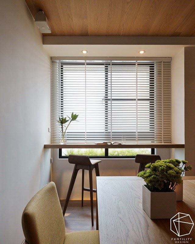 窗边吧台成了另一个惬意的使用角落，并书桌摆上一小盆绿盆栽，搭配采光的温柔照拂，在绿意与光线中，营造出文雅的读书环境。