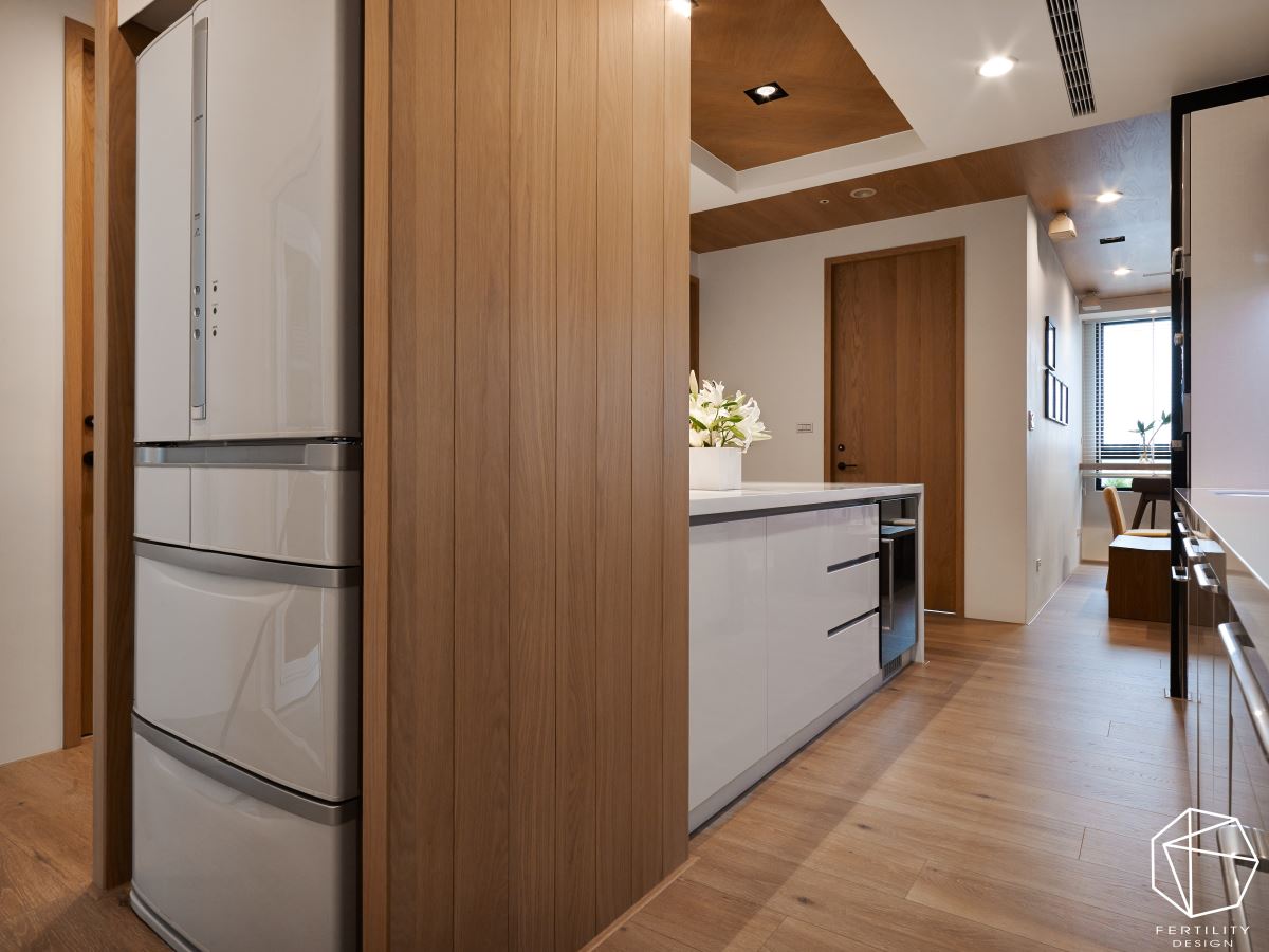 中岛餐厨利用现代化材质与木作相结合，营造利落大方的用餐场域，佐以上方镜面，更达到视觉放大效果。