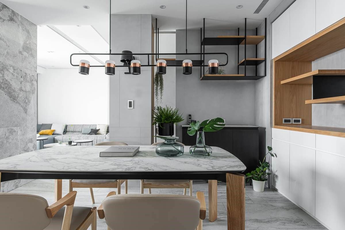 就连玄关、餐厅之间也留有空隙，让每个区域都保有互动关系，而餐桌则采用订制家具，与地面、电视墙相互呼应，呼应石材的天然质纹，并增设实用电器柜、增添收纳机能。