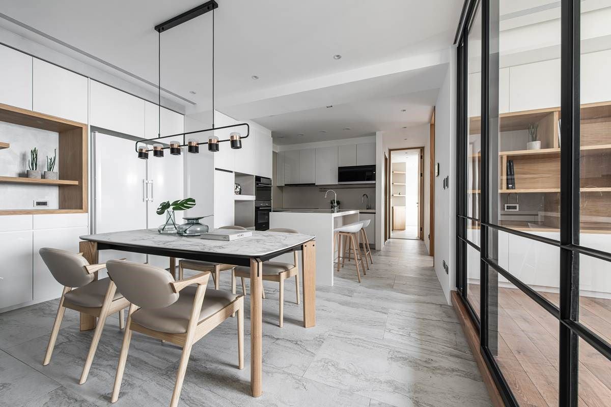 在厨房增设中岛，划出回字型动线，运用铁件、玻璃打造穿透感隔间，不只使居家空间感放大，也让光线可引导至餐厅、延续到厨房，形成明亮感，且透过透明隔间的界定，让餐厅、书房二者可保有高互动，让大人可一边料理或用餐、一边照看到孩童在书房的活动情况。