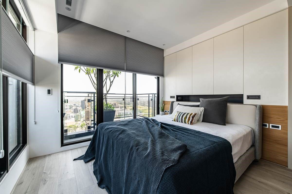 卧室内，援引窗外的日光，以两道立面开窗挹注美好光感，形塑出通透明亮的生活景况。