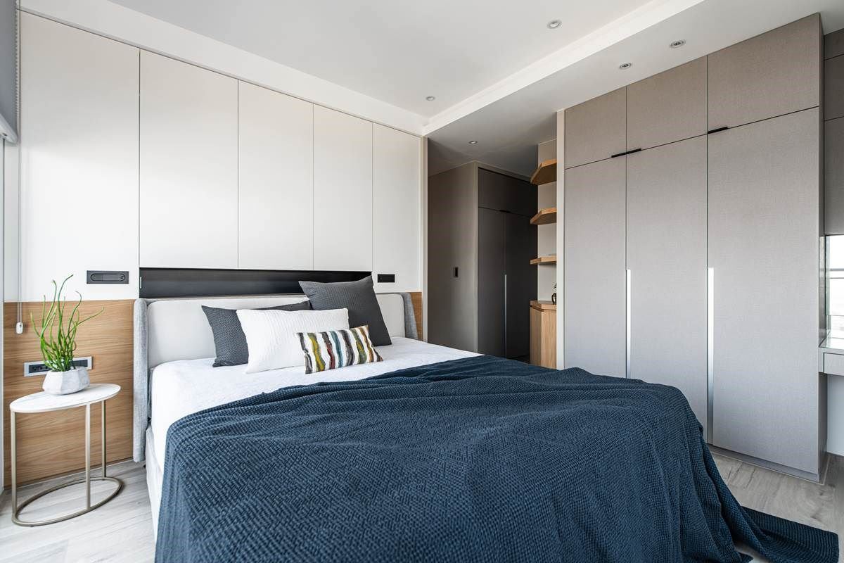 床头、衣柜都使用简洁利落的线条做勾勒，将把手化为细致的沟缝，结合恰到好处的留白设计、简约有质感的床单家具，让整体显得充满品味。