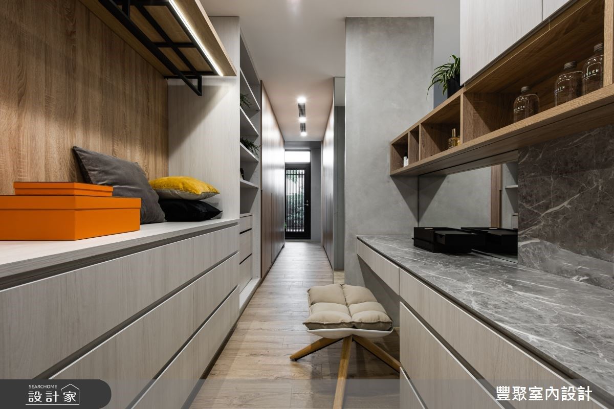 更衣间设置了齐全的收纳柜，并可通往阳台，运用落地窗引光入内，让狭长的格局依旧可享受到充足自然光。