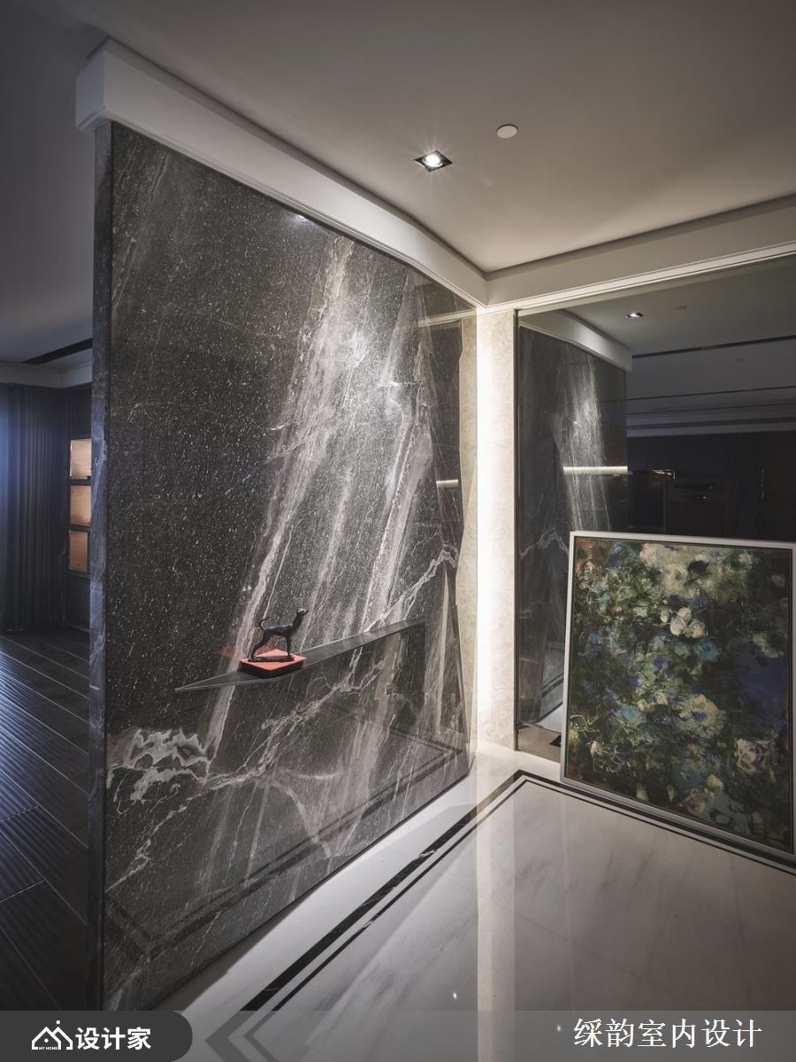 大石材作为界定玄关与公领域的隔断设计，下方嵌入细致层板，展示风格小对象，伴随光线的映照下，流露艺术丰采。