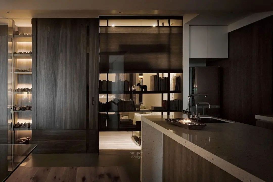 透明书柜作为隔斷墙，大胆前卫的穿透性，让两个空间的光源互相穿透，同时分享人与人生活的每一时刻。