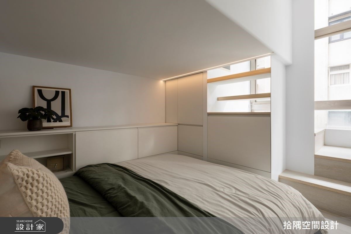 卧房及更衣室位於沙发背墙後方，划分上下层的楼梯界线，不仅让小坪数空间拥有高隐私卧室、争取更衣收纳区，更化解窗边梁柱缺陷难题。